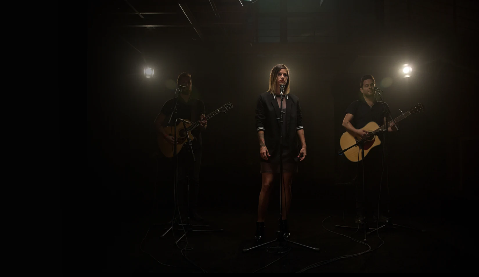 Artists performing on a dark stage
